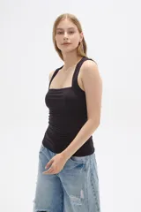 Musculosa negra ajustada al cuerpo, sin mangas y con cuello recto.