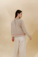 Saco tejido color negro con detalle en escote y puños a dos tonos, corte acampanado y detalle en la espalda con cambio de punto y color.