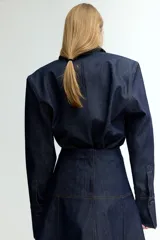 Pollera midi de denim azul oscuro, corte evasé y costuras verticales decorativas.
