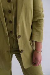 Conjunto de blazer, chaleco y pantalón color verde pistacho. El blazer es de corte clásico con solapas y cierre de dos botones. El chaleco es entallado con cierre de botones. El pantalón es de corte palazzo.
