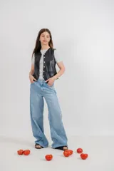 Chaleco color arena de cuero ovino, con cuello en V y cierre frontal con botones.