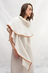 Chal de lino color natural con ruedo color ladrillo. Diseño versátil que permite usarlo extendido o enroscado como cuello.