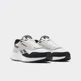 Championes Reebok Classic Leather 2400 con capellada de cuero y gamuza en blanco, negro y gris. Entresuela de EVA y detalles reflectantes.