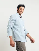 Camisa celeste de manga larga con cuello button-down, confeccionada en tejido rústico de algodón y lino.