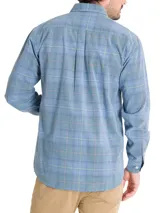 Camisa de franela de algodón orgánico a cuadros en tonos azul, gris y verde. Tiene cuello camisero, manga larga, un bolsillo en el pecho y cierre con botones.