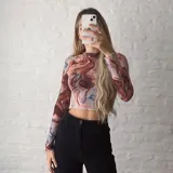 Top de microtul con estampado abstracto en tonos marrones, celestes y blancos, de cuello alto y mangas largas.