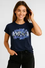 Remera azul marino de algodón con cuello redondo y mangas cortas. Estampado frontal con la palabra "AMOUR" en letras blancas rodeada de flores azules.