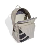 Mochila gris con el logo de Adidas en negro. Cuenta con un compartimento principal con cierre, un bolsillo frontal con cierre, bolsillos laterales y correas acolchadas ajustables.