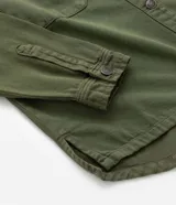 Campera plus size color verde militar, modelo oversized, confeccionada en sarga texturizada. Cuenta con cuello tradicional, cierre abotonado, dos bolsillos delanteros y puños abotonados.