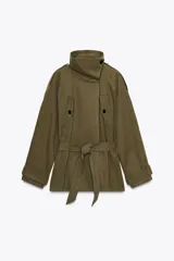 Trench color verde militar confeccionado en algodón. Presenta cuello alto, manga larga con trabillas en hombro y puño, bolsillos con solapa en delantero, cinturón lazada en mismo tejido, forro interior combinado y cierre frontal con botones.