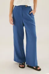 Pantalón de lino azul de corte palazzo con botón decorativo en la cintura.