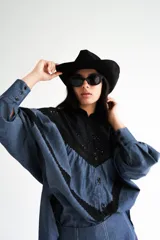 Blusa de mangas globo confeccionada en denim celeste con canesú de encaje negro y detalles de puntilla negra.