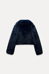 Abrigo corto azul marino de piel sintética, con cuello solapa y manga larga. Tiene bolsillos laterales ocultos en la costura, forro interior combinado y cierre frontal con gancho metálico forrado.