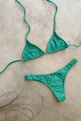 Conjunto de bikini verde esmeralda, con corpiño triangular de atar al cuello y espalda, con almohadillas desmontables, y bombacha colaless con laterales fijos.