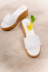 Sandalia con plataforma de corcho y capellada tejida de cuero vacuno color beige.