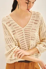 Sweater tejido de algodón color marrón claro, con escote en V y mangas 3/4 amplias.