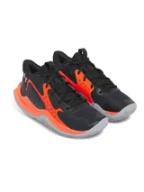 Championes de básquet Under Armour UA GS Jet 23, color negro con detalles en naranja y suela gris. Presentan capellada de malla transpirable y entresuela Micro G para amortiguación.