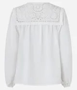 Blusa blanca amplia de viscosa, con lazo delantero, mangas largas abullonadas y canesú con encaje richelieu.