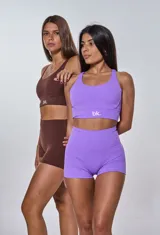 Conjunto deportivo violeta compuesto por un top con breteles cruzados en la espalda y logo "bk." en el frente y un short de calce ajustado.