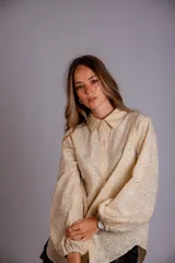 Camisa celeste con estampado de flores blancas, corte clásico, cuello camisero y mangas largas abullonadas.