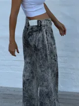 Jean de mujer color gris con efecto acid wash, de tiro alto y corte recto. Presenta costuras verticales en la parte delantera y bolsillos laterales.