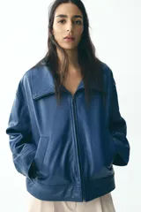 Cazadora azul de piel con cuello solapa, manga larga, bolsillos de vivo en delantero y cierre frontal con cremallera.