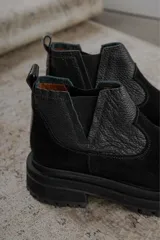 Botas Chelsea color marrón con paneles laterales elásticos y suela track.