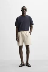 Bermuda negra regular fit confeccionada en tejido de algodón con estructura. Cintura elástica ajustable con cordón, bolsillos laterales y bolsillo trasero de vivo.
