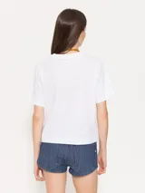 Remera blanca de algodón con estampado de limones, de corte clásico, cuello redondo y mangas cortas.