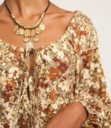 Blusa de manga larga confeccionada en viscosa con cuello redondo, lazo en el escote, abertura debajo del escote y estampado abstracto.