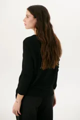 Sweater azul de tejido de punto con cuello redondo y mangas largas.