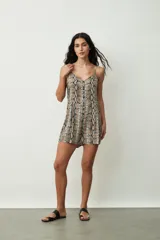 Mono corto color crudo, con breteles finos, escote en V y cierre frontal con botones.