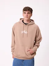 Canguro color beige de la marca Rusty, con capucha y cordones ajustables. Presenta un bolsillo tipo canguro en la parte delantera y el logo de la marca estampado en blanco en el pecho.