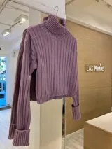Sweater de punto color verde oliva, con cuello alto y mangas largas con puños acanalados.