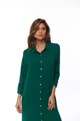 Vestido camisero verde esmeralda con botones blancos, de corte recto y largo a la rodilla. Tiene cuello camisero y mangas 3/4.