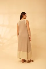 Vestido largo sin mangas de tejido de punto, color terracota, con cuello redondo y borde negro brillante. El ruedo del vestido es de color negro brillante.