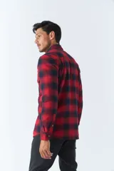 Sobrecamisa de algodón para hombre con interior de corderito, estampado a cuadros en tonos negro, blanco y azul. Tiene cierre de botones, bolsillos tipo cartera y logo en goma. El modelo usa talle M.
