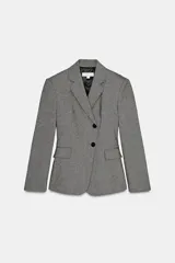 Blazer gris jaspeado de corte entallado, con cuello solapa, manga larga con hombreras, bolsillos delanteros con solapa y cierre frontal cruzado con dos botones negros.