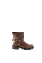 Bota corta de cuero marrón, con caña baja, base de 1,5 cm y taco de 2,5 cm. Presenta una correa con hebilla metálica alrededor del tobillo.