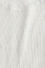 Musculosa blanca de algodón acanalado con breteles finos y escote redondo pronunciado con ribete de encaje.