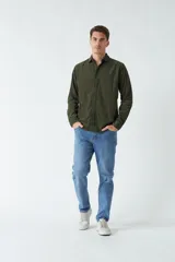 Camisa de pana color verde militar, de corte regular, con cuello clásico y cierre frontal con botones.