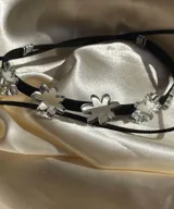 Gargantilla negra con dije de flores espejadas.