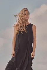 Vestido midi negro de tejido fluido, con cuello redondo y sisa. Cierre trasero con cremallera oculta.