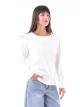Remera blanca de manga larga con cuello redondo y detalle de botones dorados en los hombros.