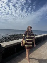 Vestido corto tejido con lurex, con cuello polo y diseño a rayas verticales en tonos marrón, amarillo y blanco.