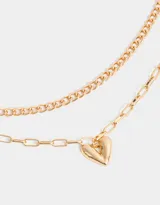 Collar corto dorado multicadena de metal con distintos eslabones y dije de corazón.