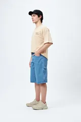 Bermuda carpenter de denim negro, corte relajado y largo a la rodilla, con costuras visibles y múltiples bolsillos funcionales.