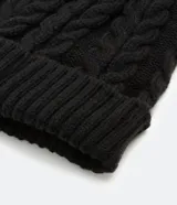 Gorro de tejido acrílico negro con diseño acanalado y trenzado en la parte superior.