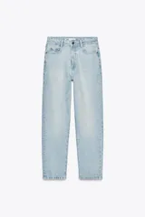 Pantalón de jean celeste claro, tiro alto, corte mom fit, tobillero, con cinco bolsillos y cierre frontal con cremallera y botón.