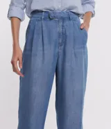 Pantalón pantalona de jean celeste, de corte ancho, con cintura media desplazada, pliegues delanteros y bolsillos.